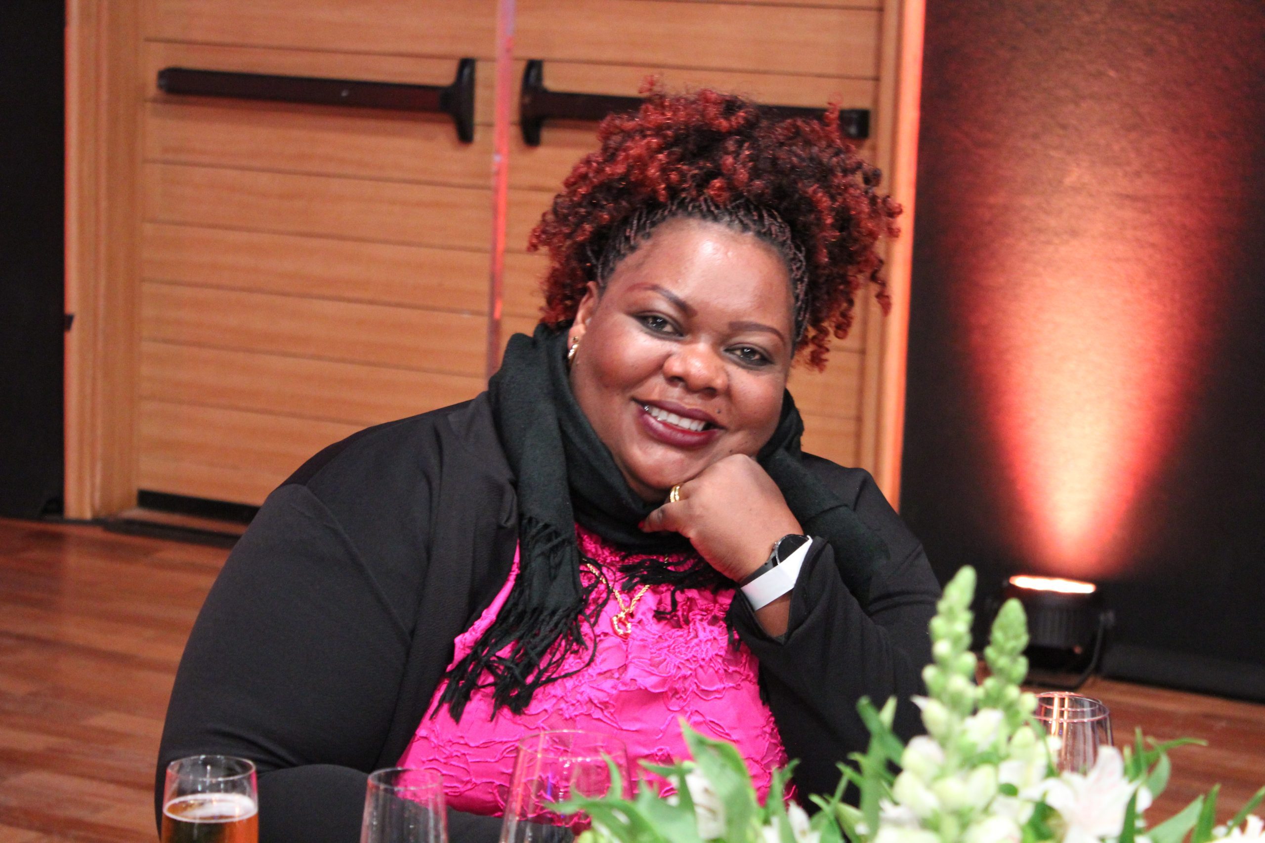A photo of a women sitting and smile affectionately at the WBU World Blindness Summit conference.